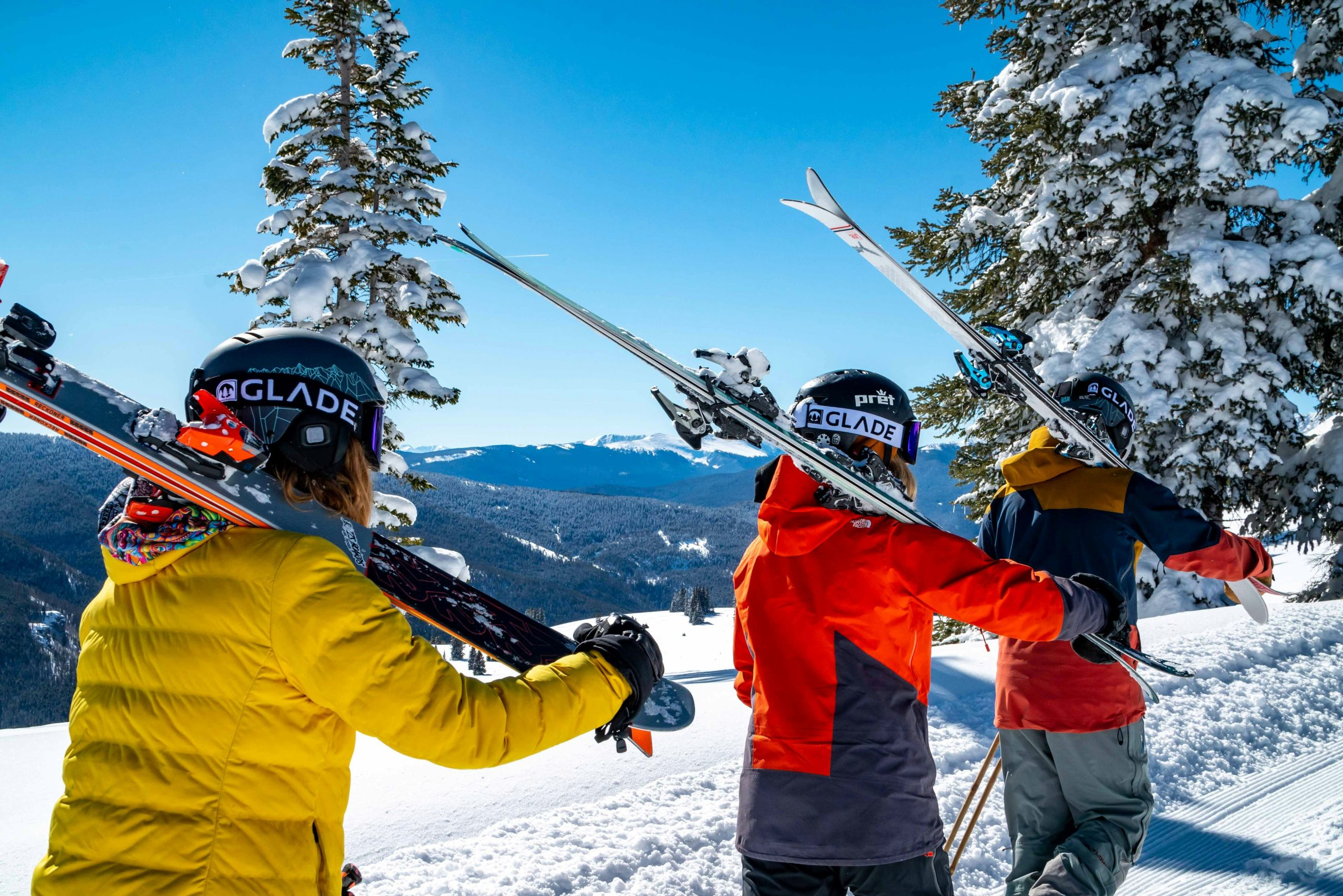 Esquiadores con los esquís al hombro en la nieve